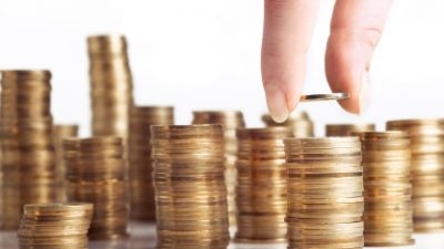 תוכנית חיסכון ריבית - בחורה מוסיפה מטבע לערימת מטבעות