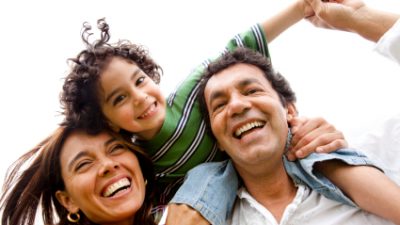 חיסכון לילדים - זוג הורים מחייך עם ילד רכוב על גבו של האב