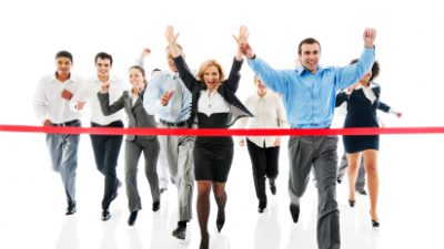 אנשי עסקים רצים לסיום התחרות וחוצים סרט אדום ומרימיים ידיים לאות נצחון