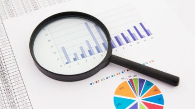 זכוכית מגדלת מונחת על דוחות כספיים