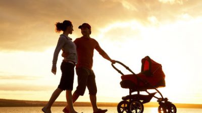 חידכון לילדים - זוג הורים מאושרים הולכים בשקיעה עם עגלת תינוק