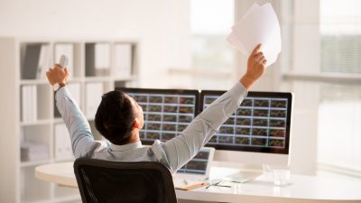 תיק השקעות - אנליסט פיננסי מרים ידיים גבוה באוויר כאות שמחה להצלחה