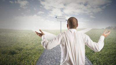 קרן השתלמות טובה - אדם מרים ידיו מעלה, מהרהר ומעלה ספק באיזה שביל לבחור.