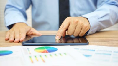 חיסכון מנוהל - ברוקר מחפש מניות בטאבלט שלו.