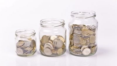 תוכנית חיסכון סולידית - שלוש צנצנות מסודרים מהקטן לגדול שבתוכם מטבעות.