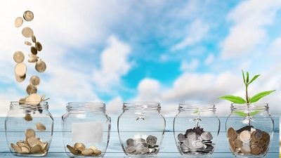 צנצנות שקופות מלאות במטבעות על רקע של שמים