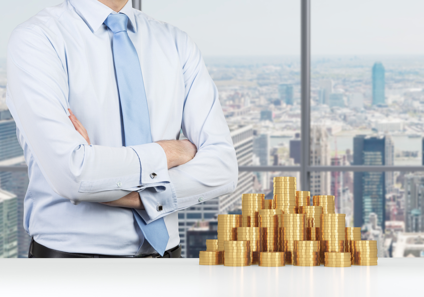 קופה מרכזית לפיצויים - איש עסקים עומד במשרד וערימה של מטבעות זהב מונחים על השולחן.