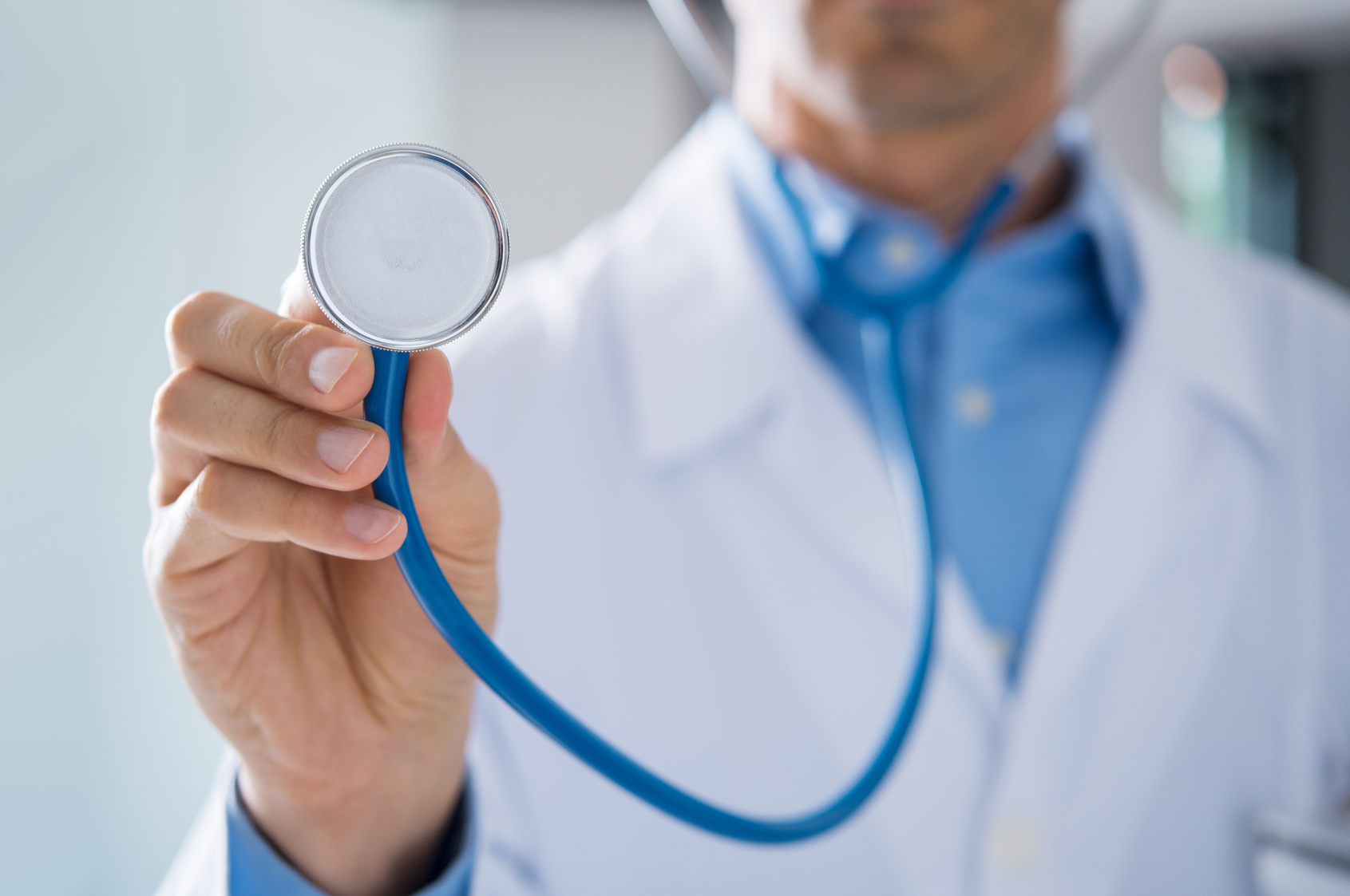 רופא מחזיר סטתוסקופ ולבוש בז'קט לבן ועונה כמה עולה ביטוח בריאות פרטי למשפחה עם ילדים קטנים