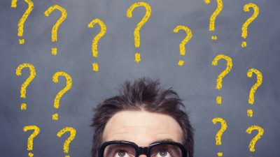 מלא סימני שאלה מצויירים על לוח ולפניו עומד אדם עם משקפיים ומנסה להבין איך לבחור קרן השתלמות