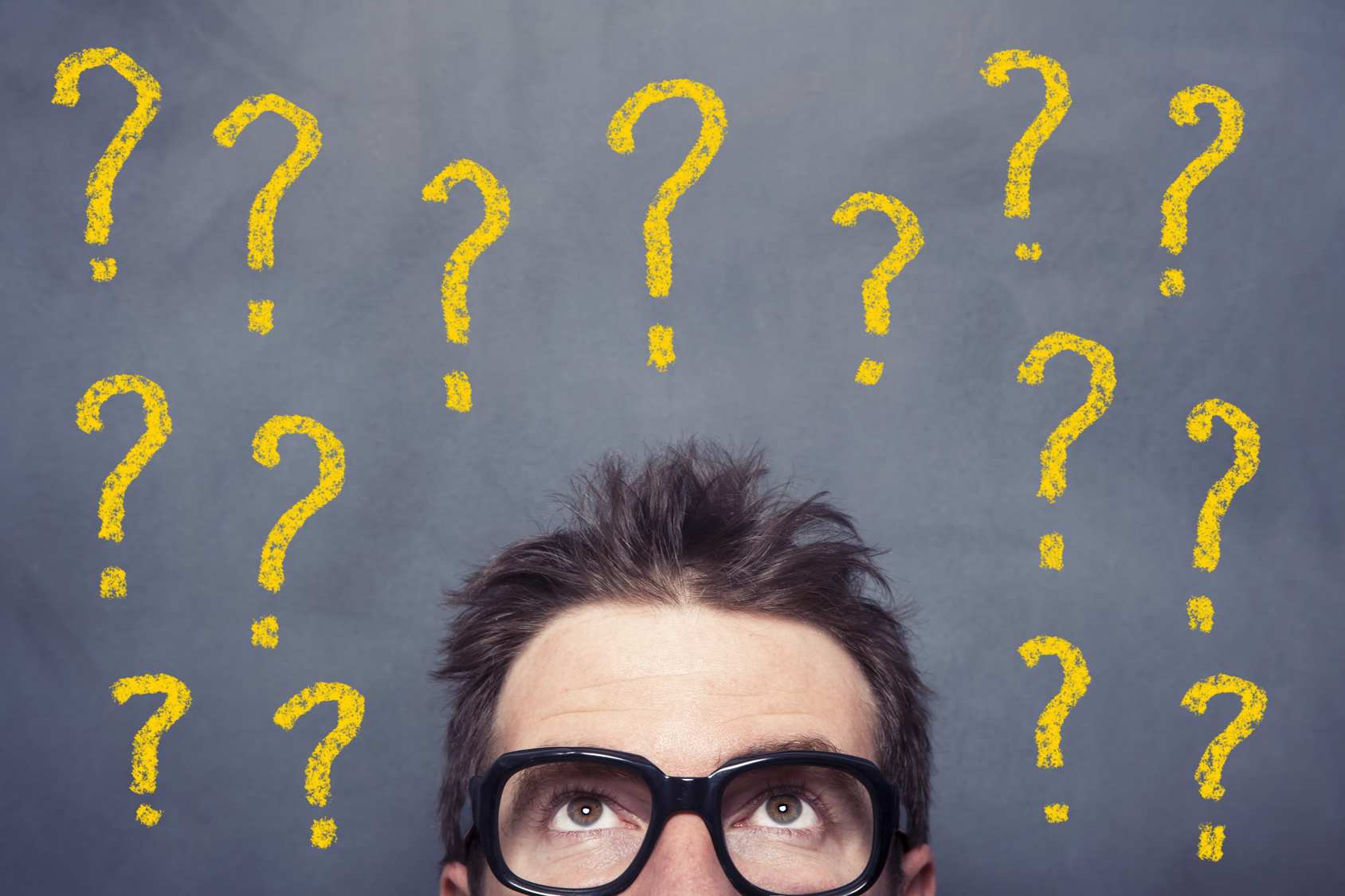 מלא סימני שאלה מצויירים על לוח ולפניו עומד אדם עם משקפיים ומנסה להבין איך לבחור קרן השתלמות
