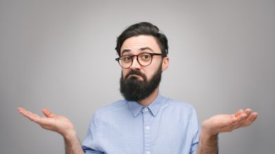 איש מבולבל עם זקן מחזיק את ידיו באוויר כאילו לא יודע מה ואיך חוסכים בעלויות הביטוח