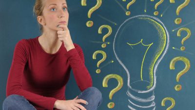 בחורה יושבת ומאחוריה לוח עם סימן שאלה איך יודעים אם ביטוח בריאות שלכם הכי טוב