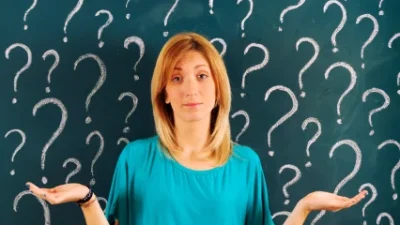 בחורה מהרהרת ופורסת ידיים ומאחורה לוח גיר עם הרבה סימני שאלה: כמה כסף צריך לחסוך לפנסיה?