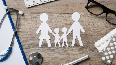 מבט על גזירת נייר בצור משפחה על שולחן עץ ומסביב מונחים משקפיים וחבילת תרופות המסר הוא איך לעשות השוואת ביטוח בריאות כדי להגן על המשפחה